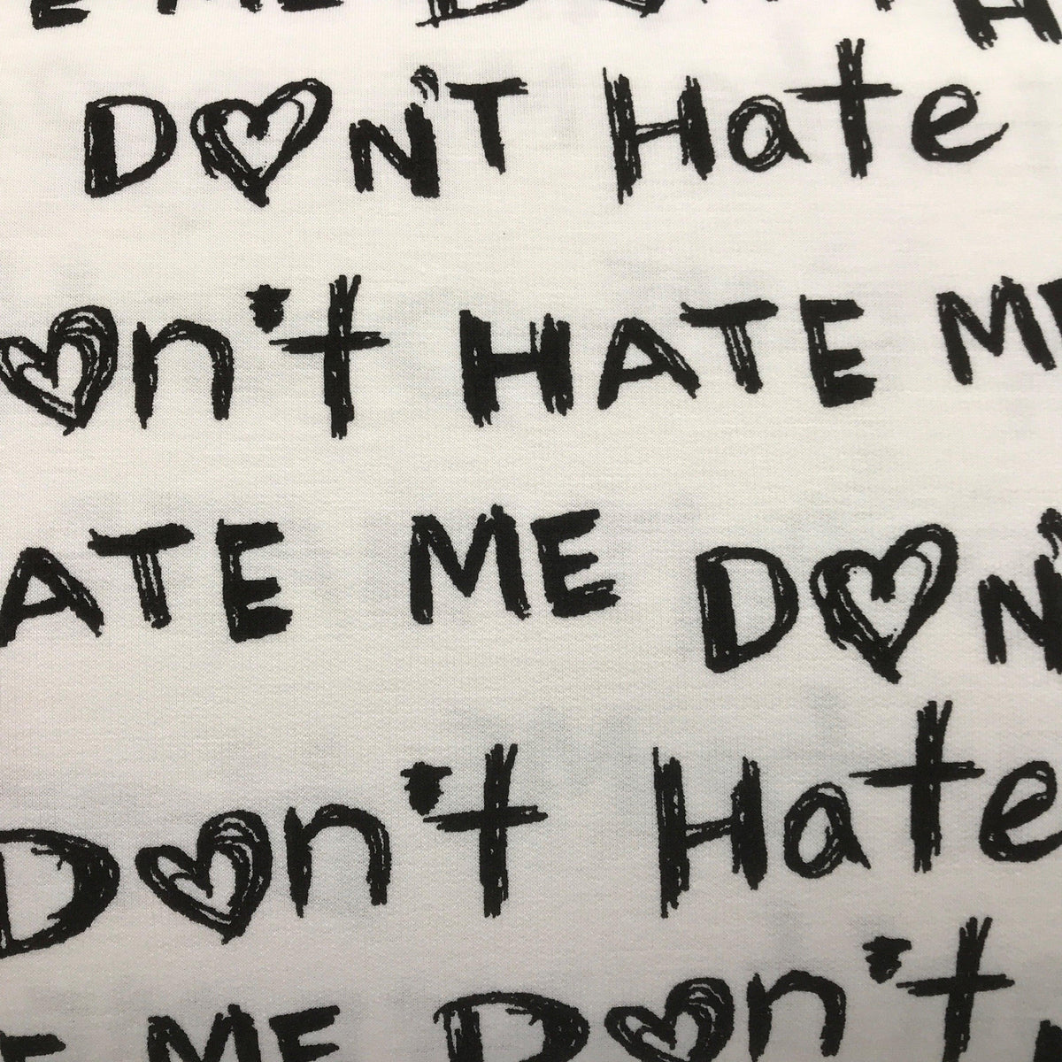 Nature's Fabrics white organic cotton fabric with black 'Don't Hate Me' text and heart patterns