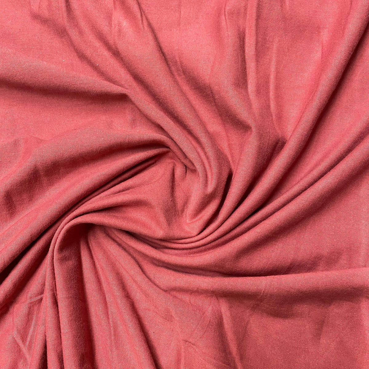Nature's Fabrics textured dusty rose organic cotton fabric swirled in a spiral pattern