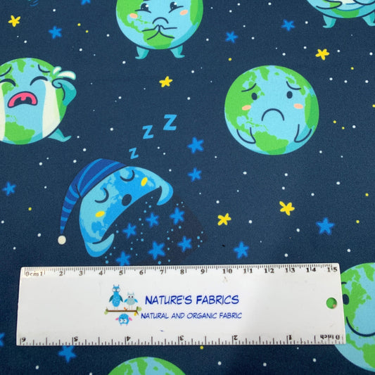 Nature's Fabrics organic cotton fabric with cute sleeping Earth characters on dark blue background.