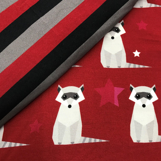 Nature's Fabrics red fabric with white raccoon and star patterns beside striped fabric.
