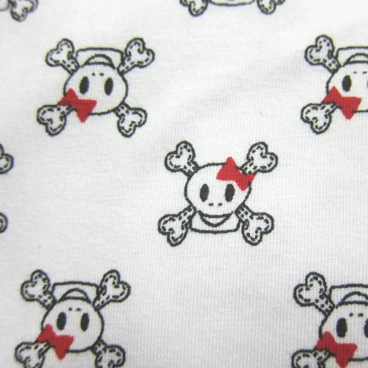 Nature's Fabrics white cotton material with a cute skull and crossbones pattern and red bows