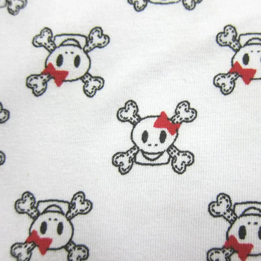 Nature's Fabrics white cotton material with a cute skull and crossbones pattern and red bows