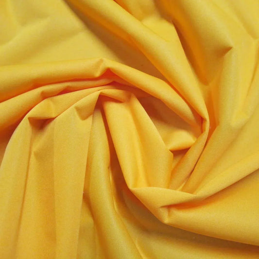 Yellow organic cotton fabric draped in folds from Nature's Fabrics