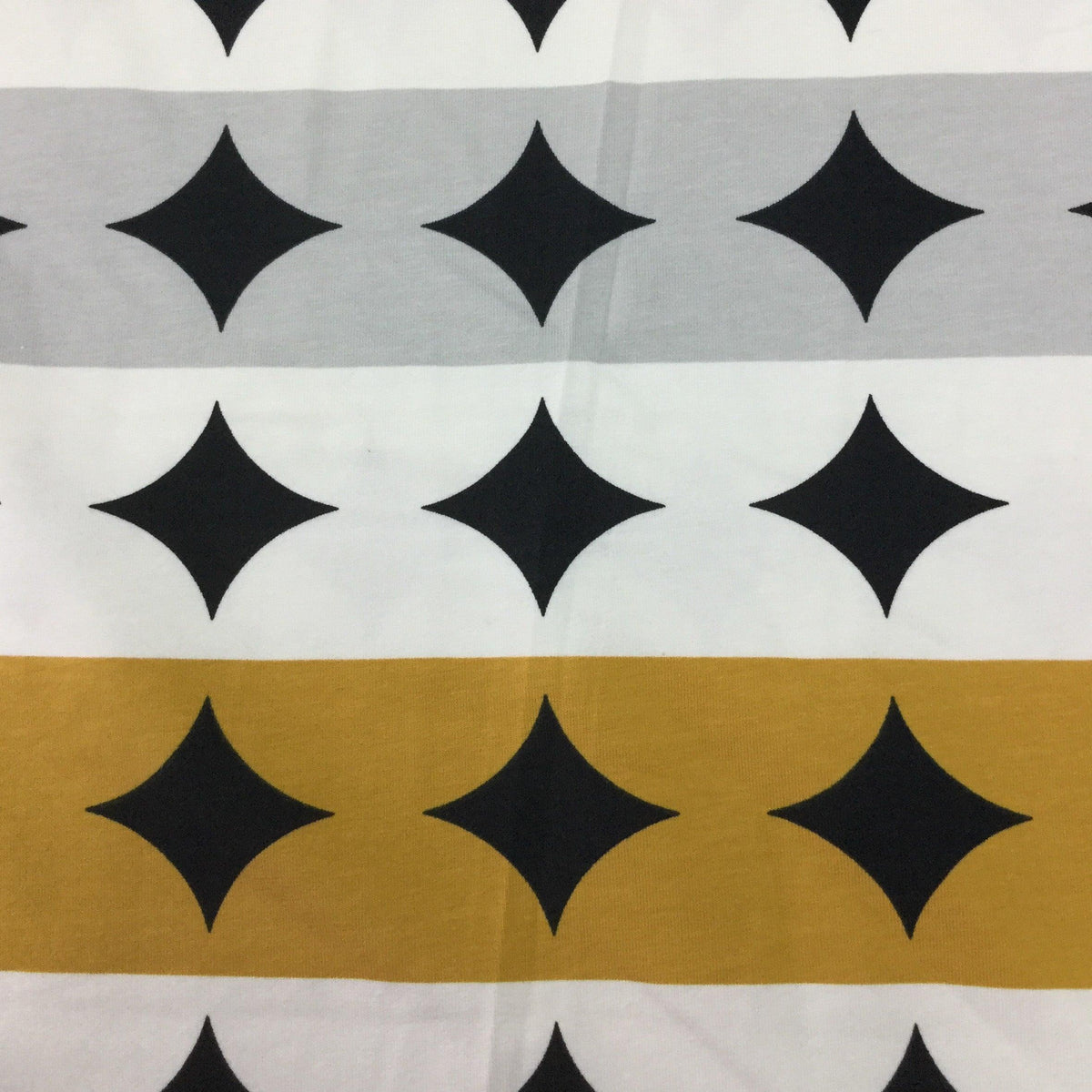 Nature's Fabrics cotton material with black diamond patterns on grey, white, and gold stripes