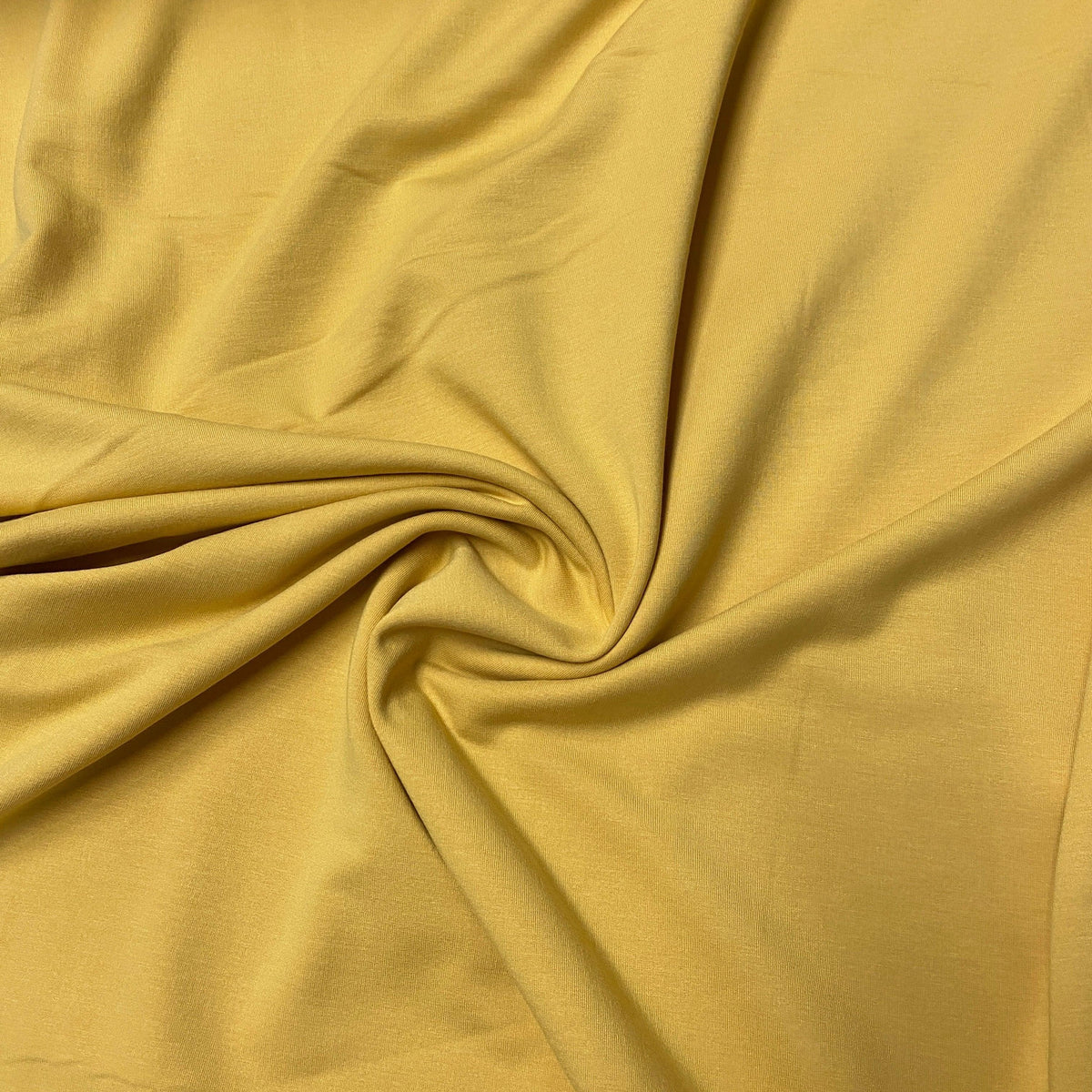 Nature's Fabrics yellow premium natural fabric draped in a soft swirl