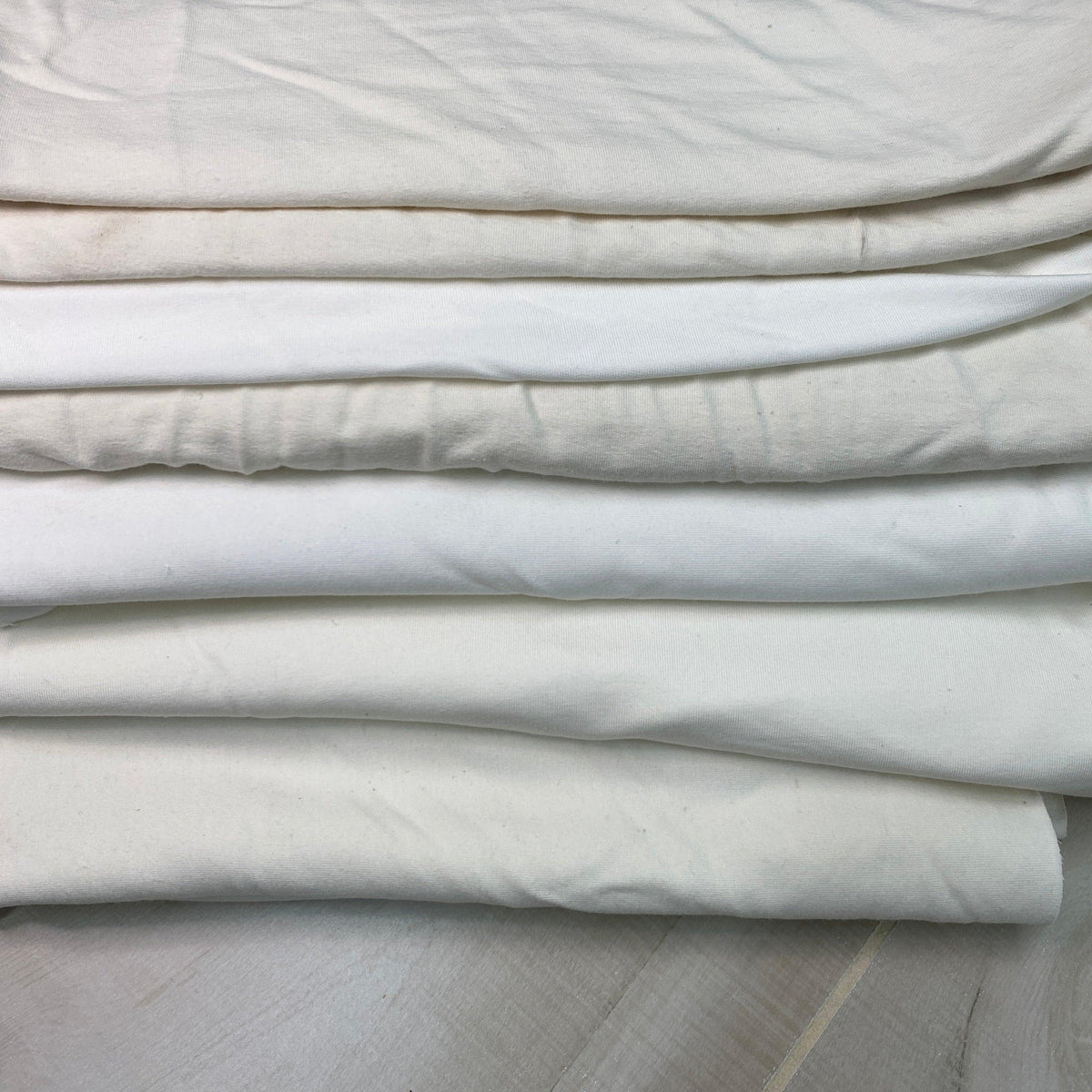 Folded stack of premium white natural fabric from Nature's Fabrics.