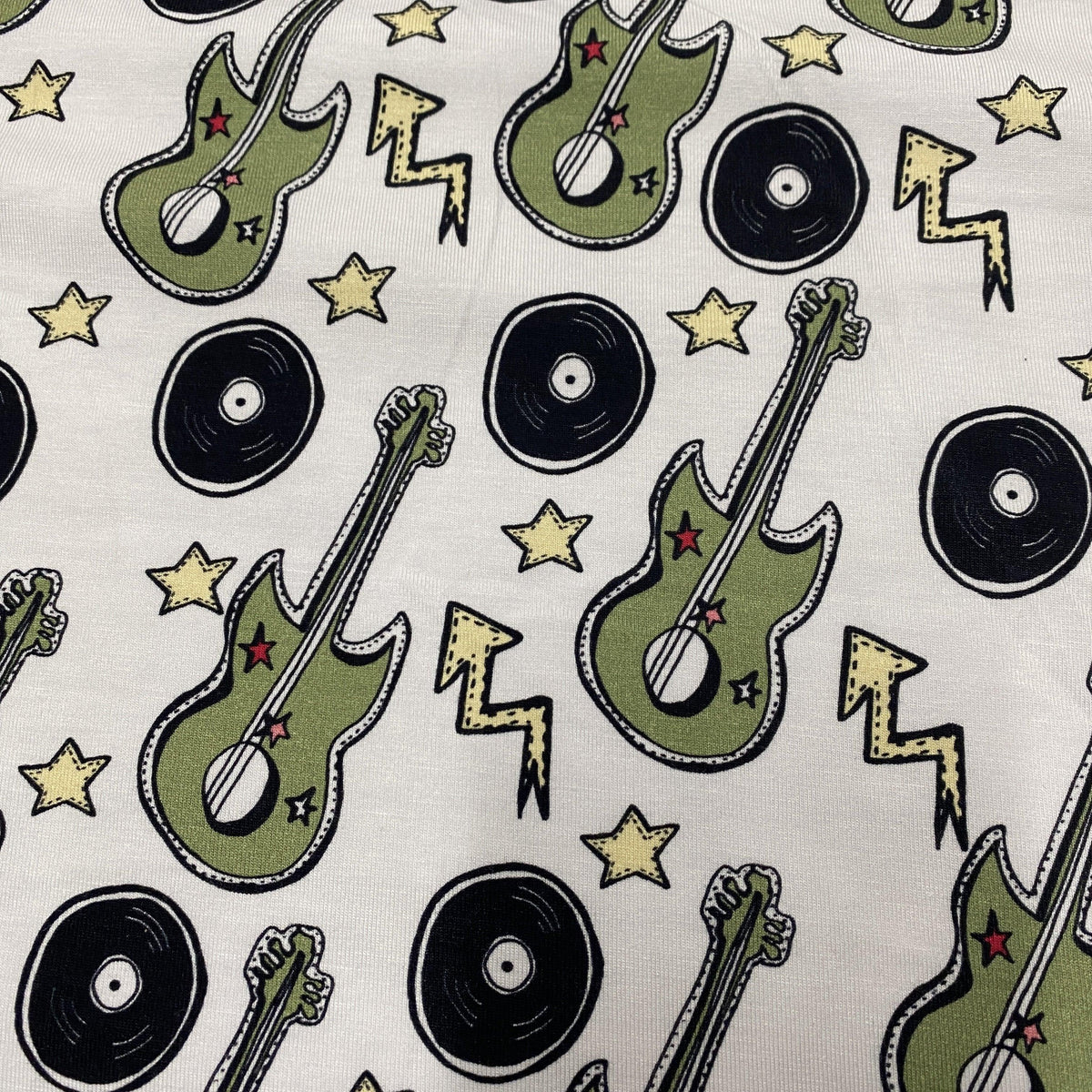 Nature's Fabrics cotton fabric with green electric guitars, vinyl records, and stars pattern.