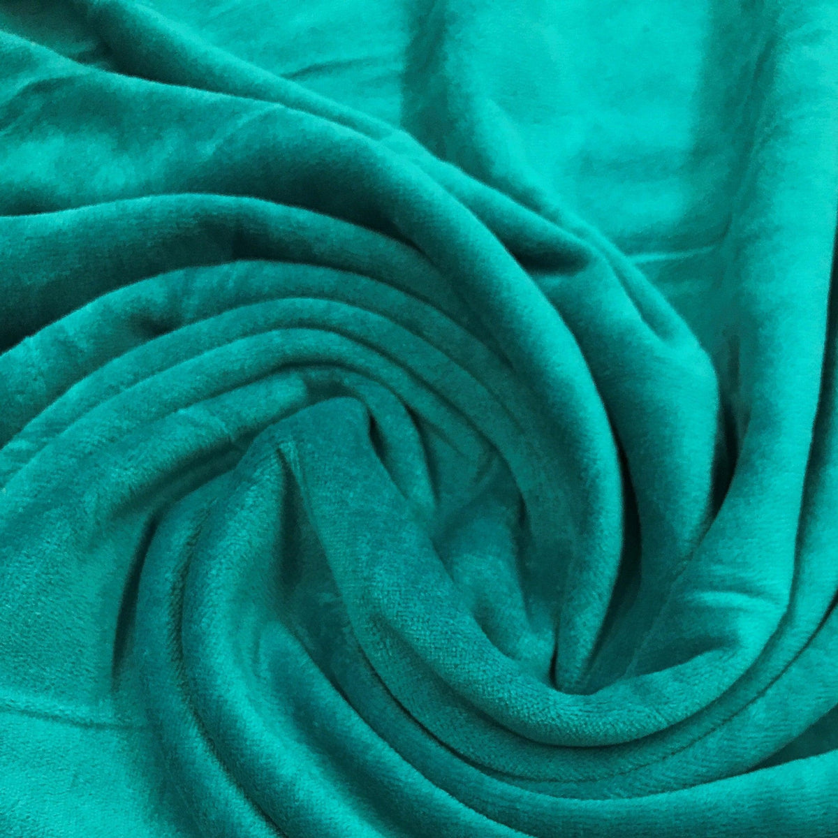 Close-up of draped teal velvet fabric from Nature's Fabrics.