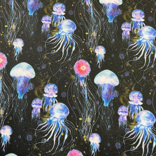 Nature's Fabrics black fabric featuring a vibrant blue and pink jellyfish pattern.