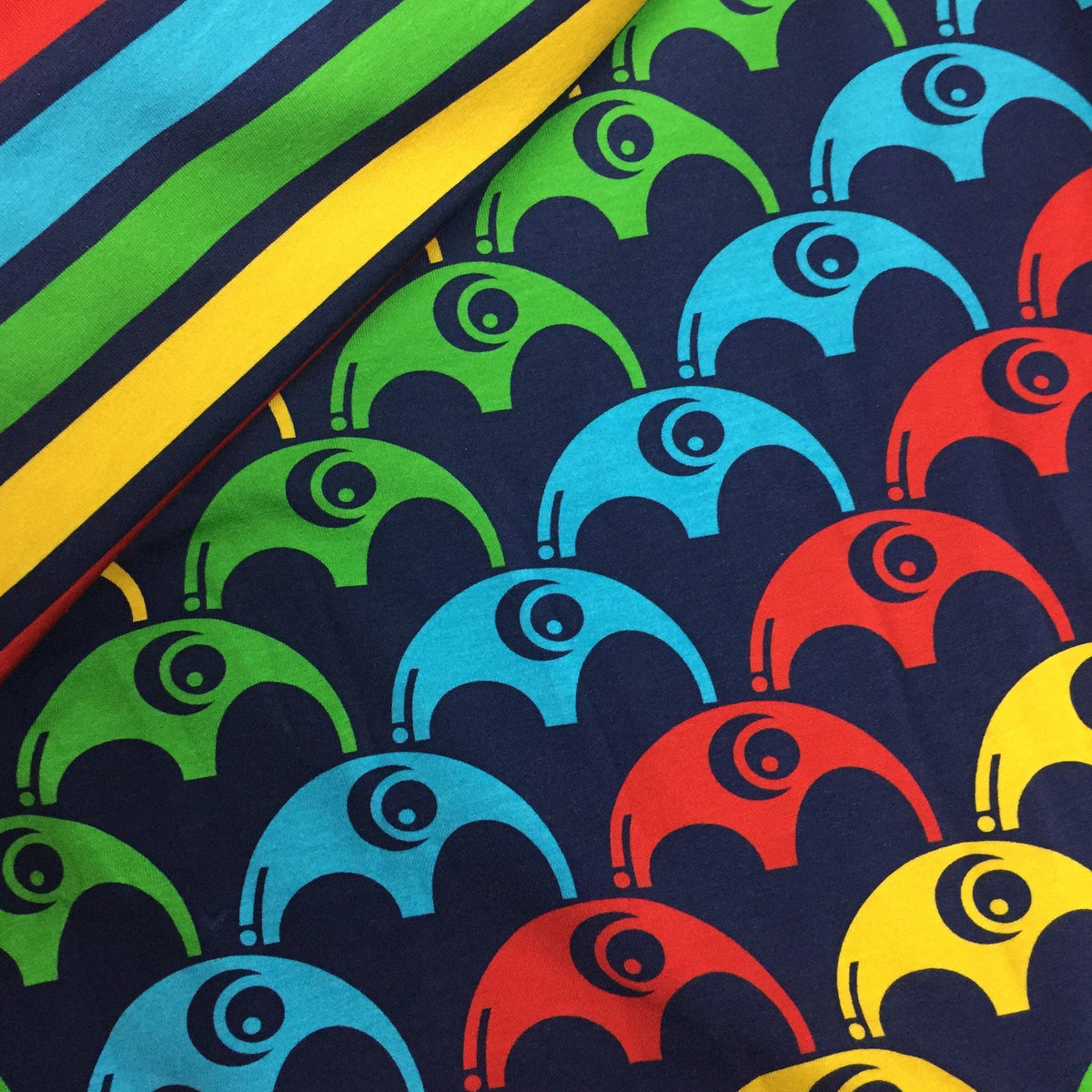 Nature's Fabrics colorful geometric pattern fabric with red, blue, green, and yellow motifs.