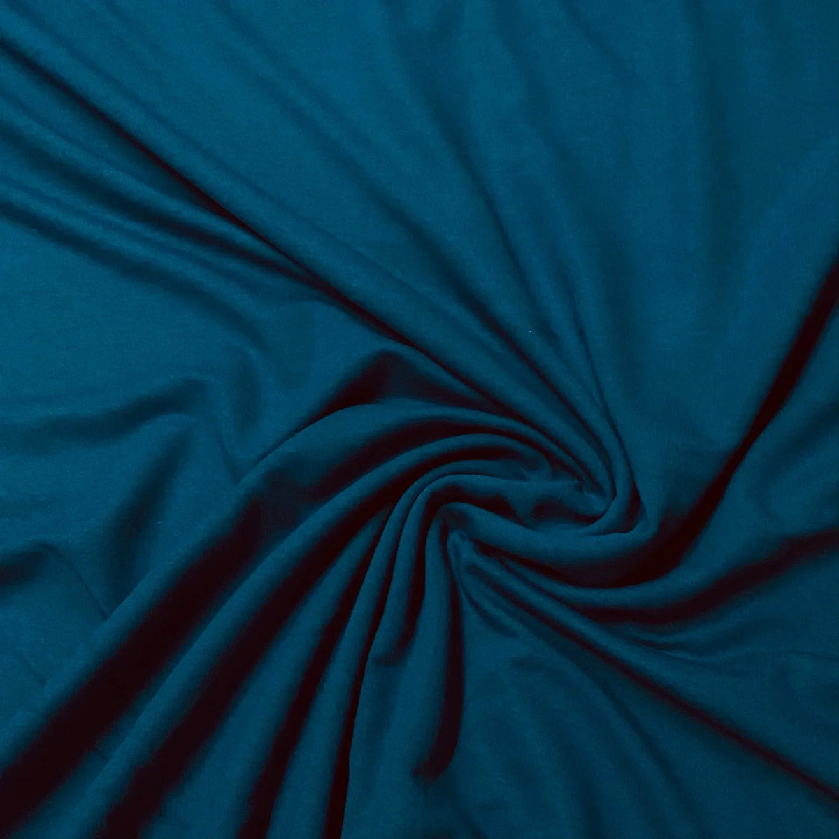 Deep teal blue premium natural fabric by Nature's Fabrics draped in a spiral fold.