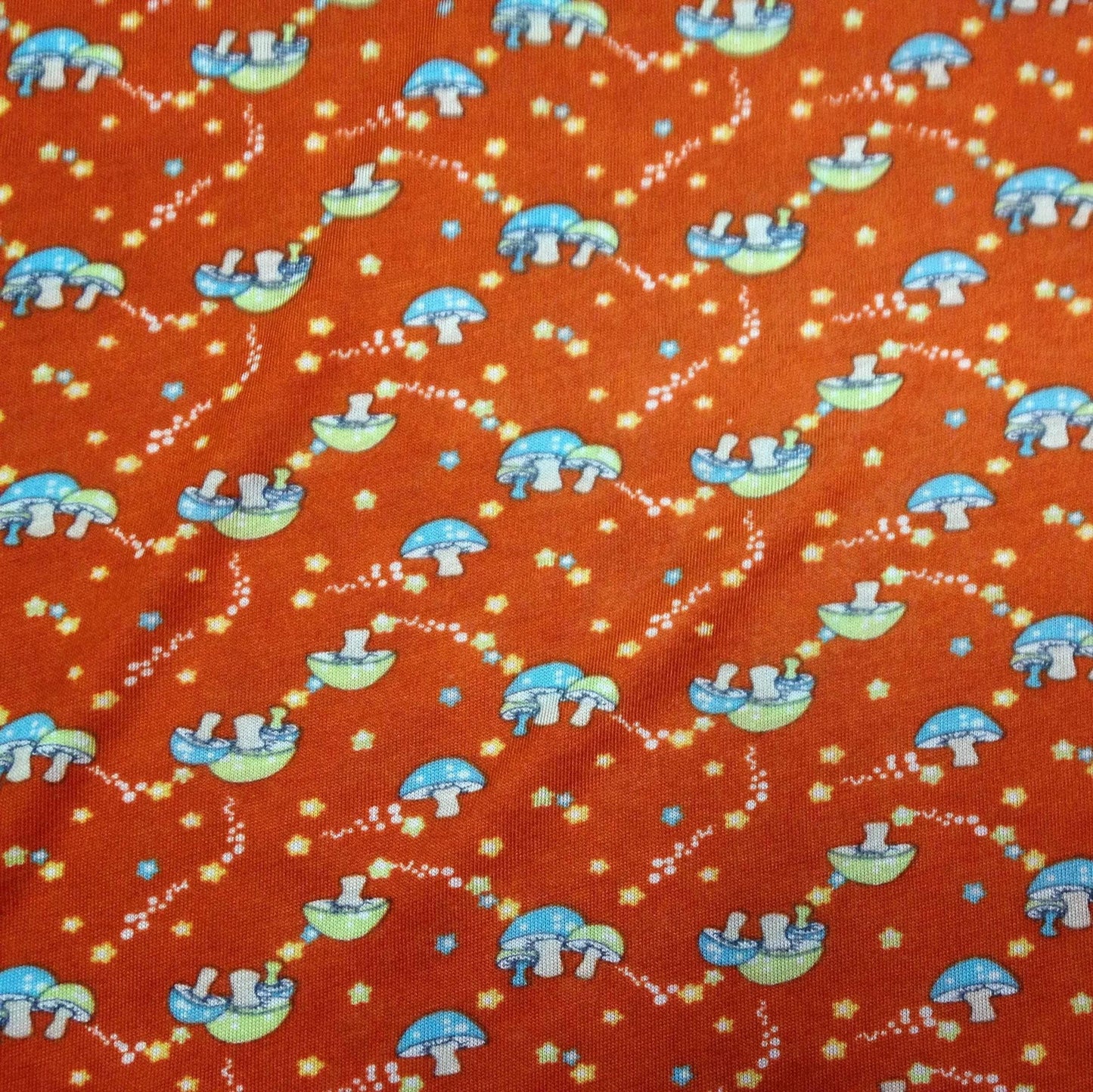 Mushrooms on Red Cotton/Poly Jersey Fabric - Nature's Fabrics