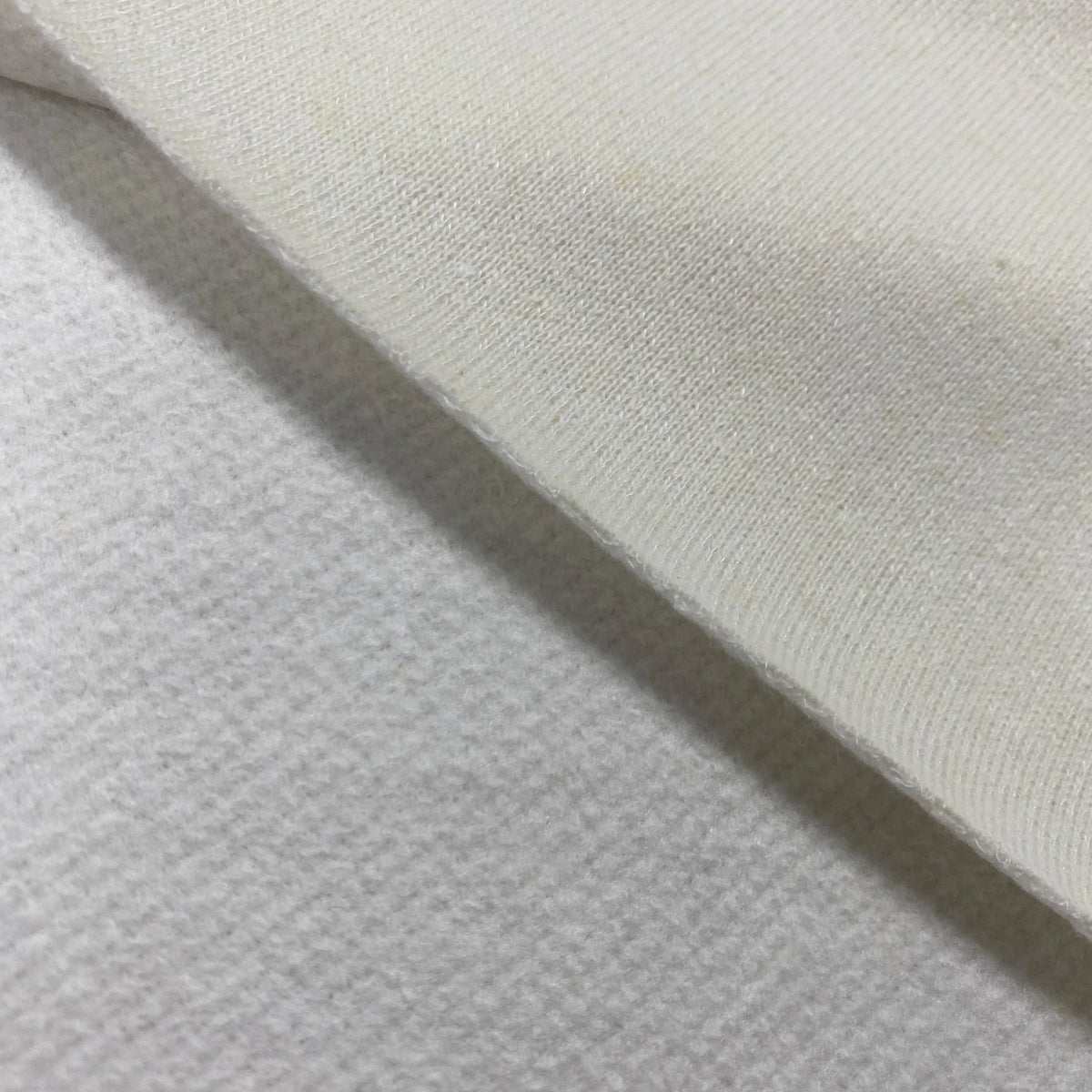 Close-up of white organic cotton fabric by Nature's Fabrics showing a soft, woven texture.