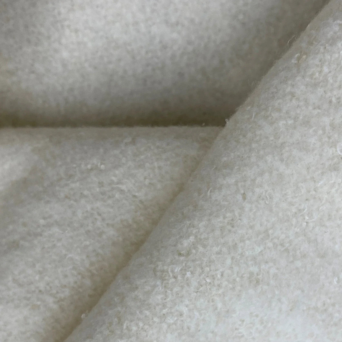 Close-up of Nature's Fabrics premium white organic wool fabric texture.
