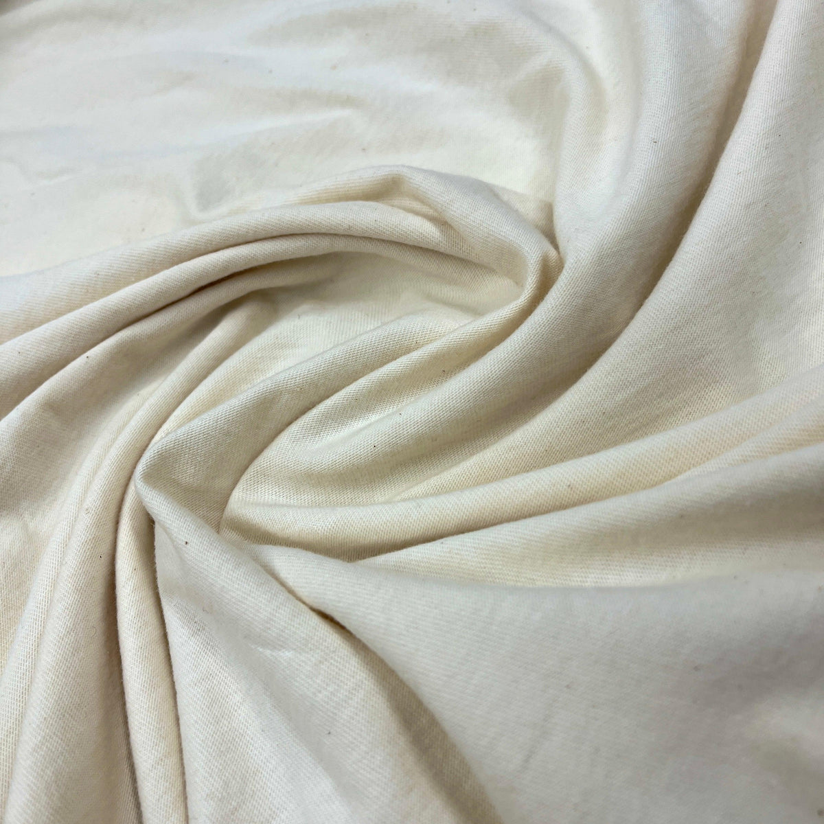 Close-up of draped off-white organic cotton fabric from Nature's Fabrics.