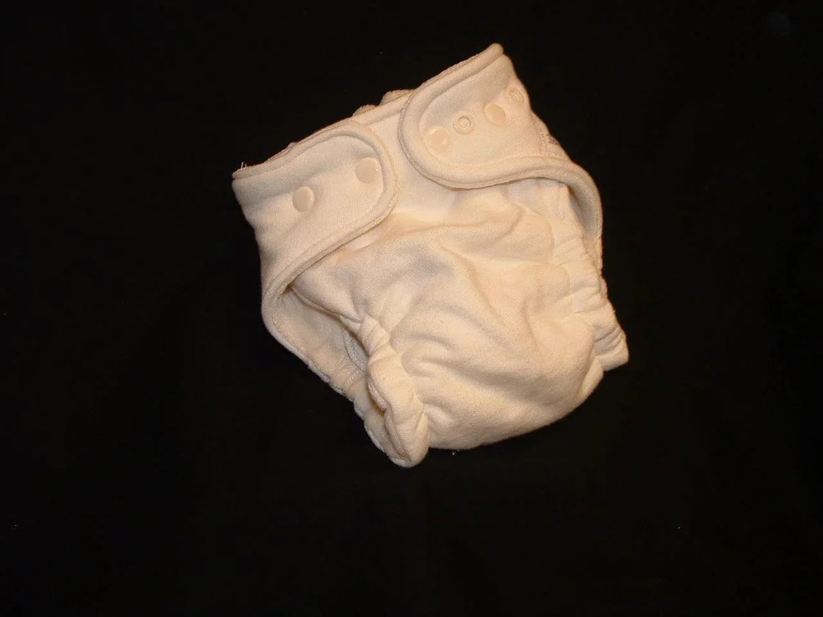 White Nature's Fabrics reusable cloth diaper with snap closures on a black background
