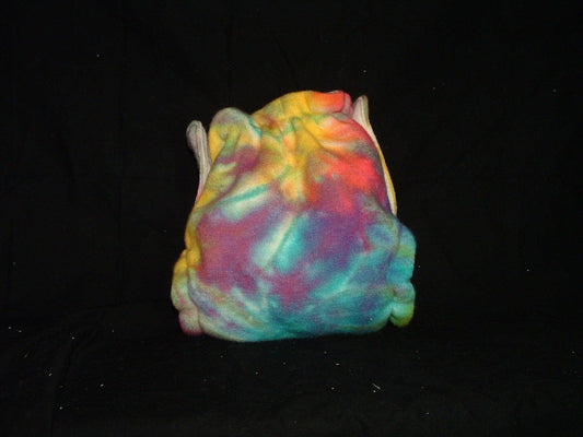 A multi-colored tie-dye fabric bag from Nature's Fabrics against a black background.