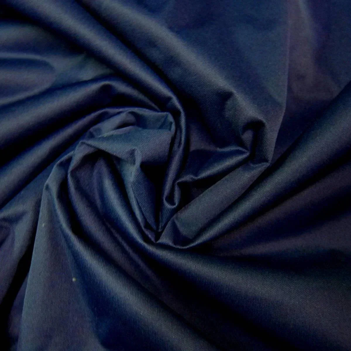 Close-up of navy blue natural fabric from Nature's Fabrics draped in elegant folds.