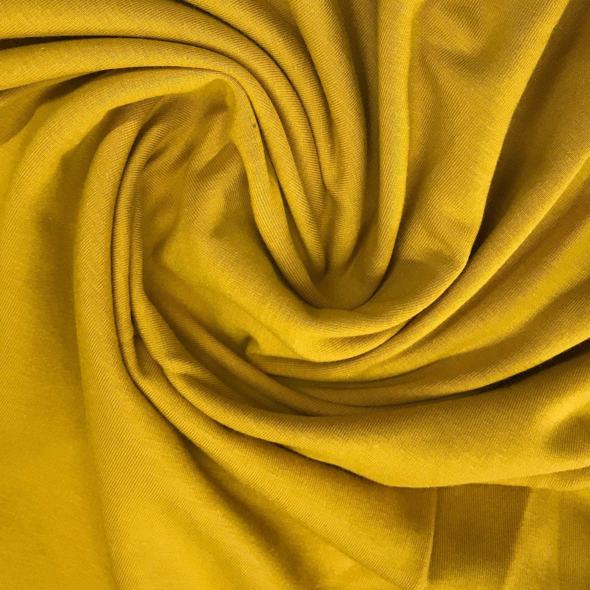Close-up of swirled yellow organic cotton fabric from Nature's Fabrics.