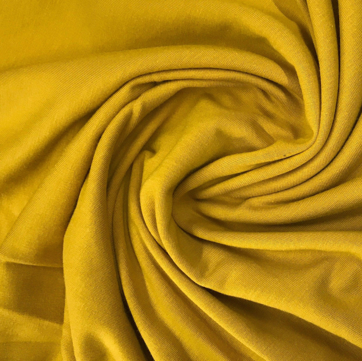 Swirl of mustard yellow organic cotton fabric from Nature's Fabrics