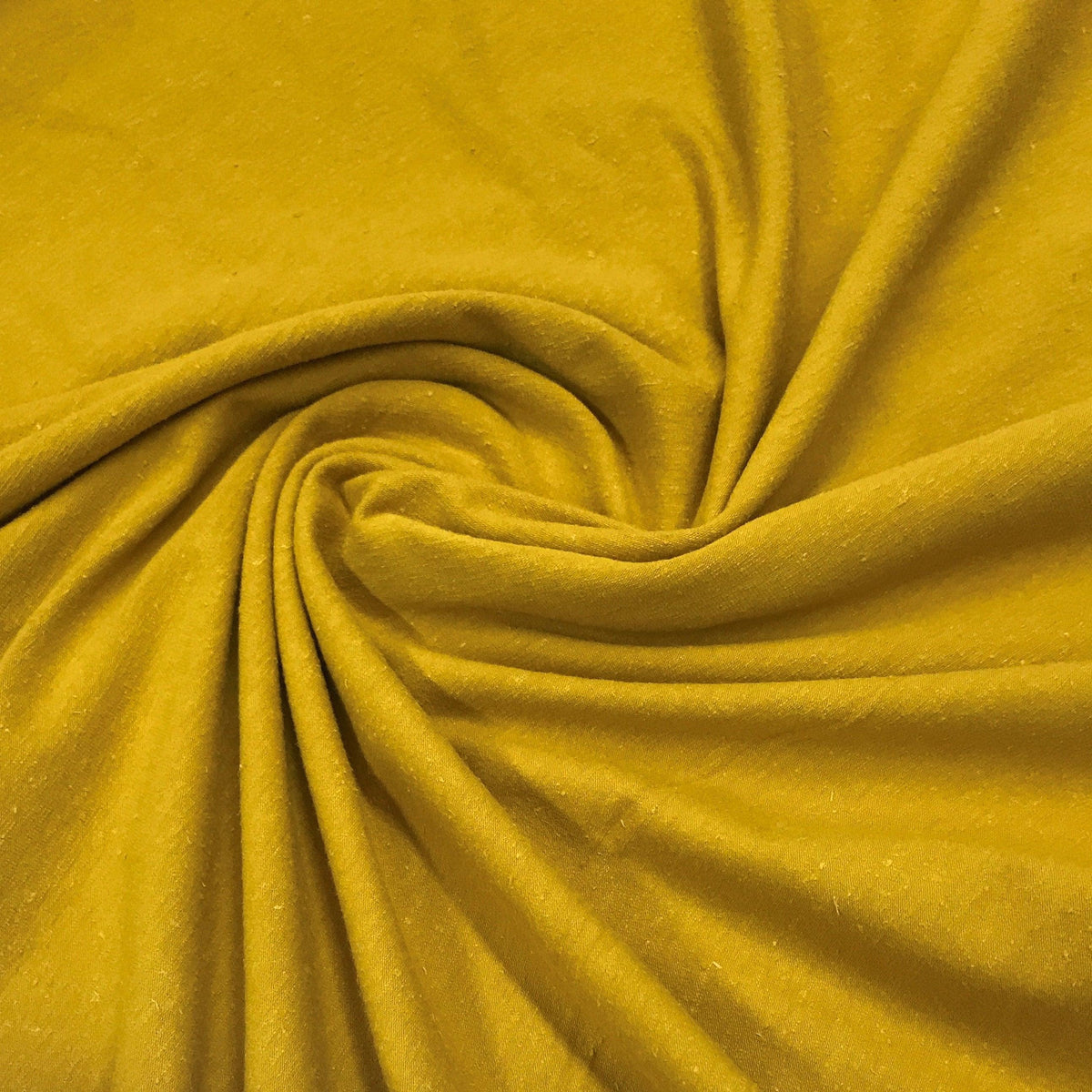 Nature's Fabrics yellow natural fabric swirled in a soft spiral pattern
