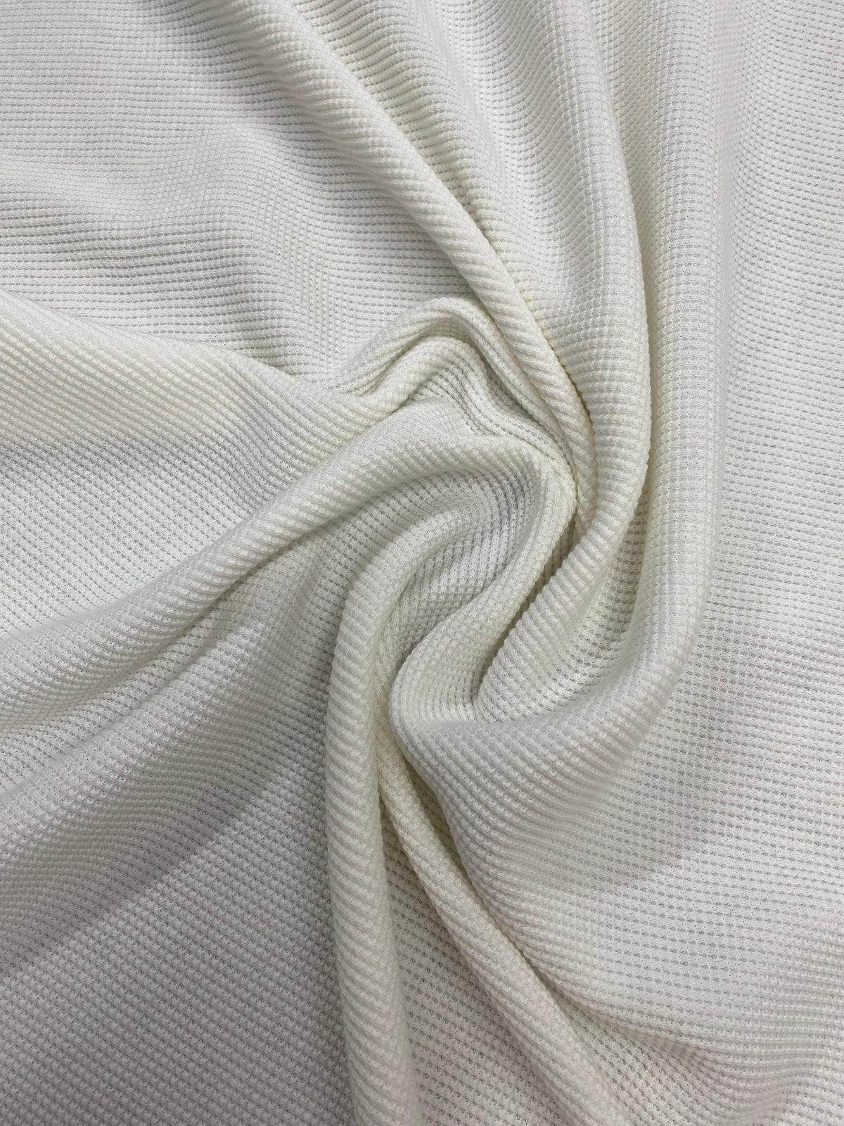 Close-up of draped white textured natural fabric from Nature's Fabrics.