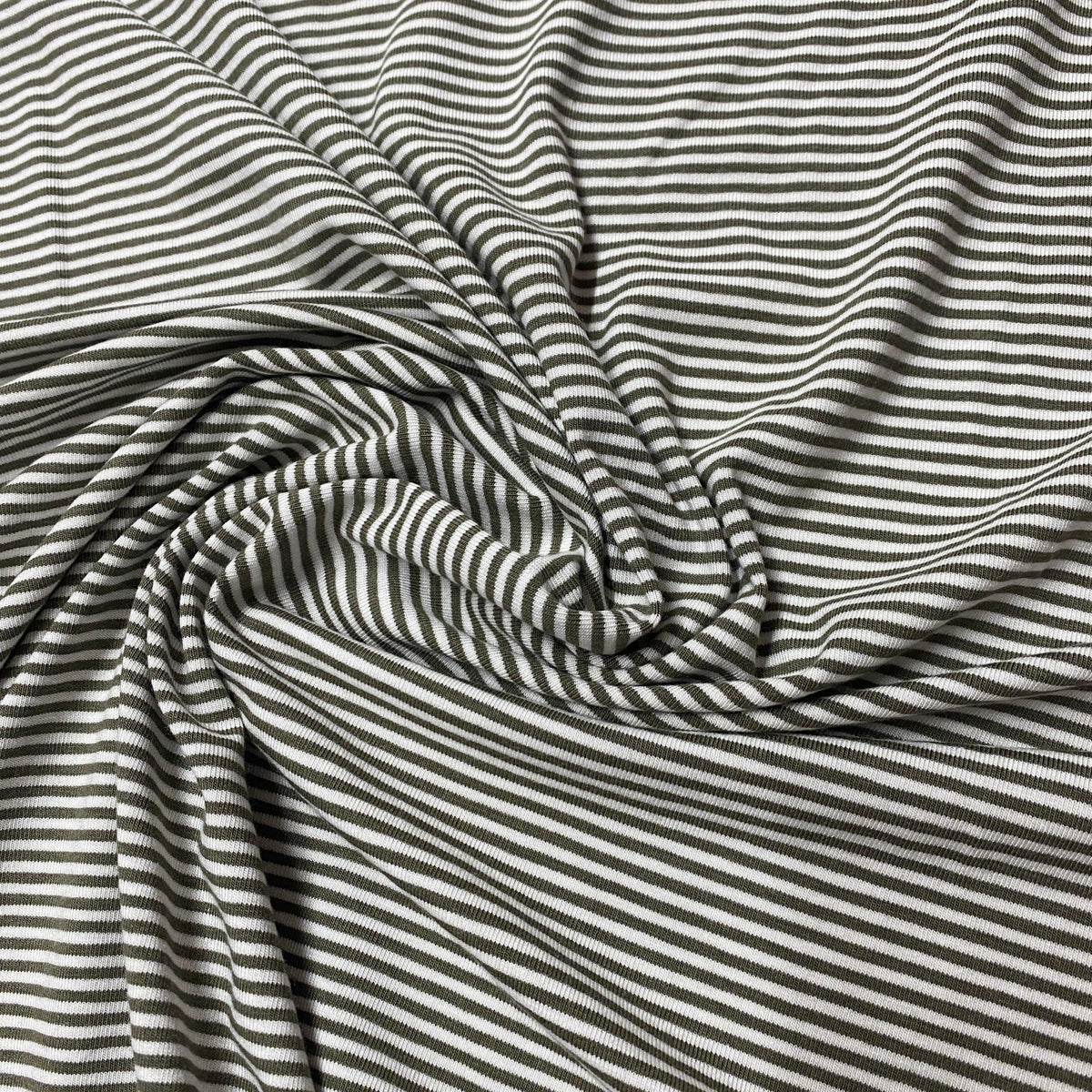 Nature's Fabrics olive green and white striped ribbed cotton fabric draped in folds