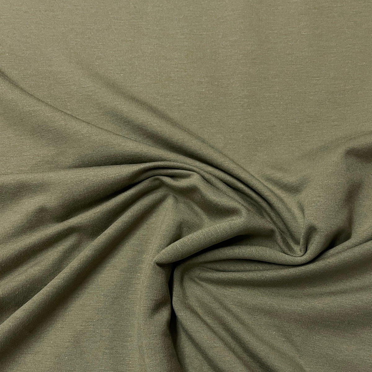 Olive green organic cotton fabric draped in folds from Nature's Fabrics