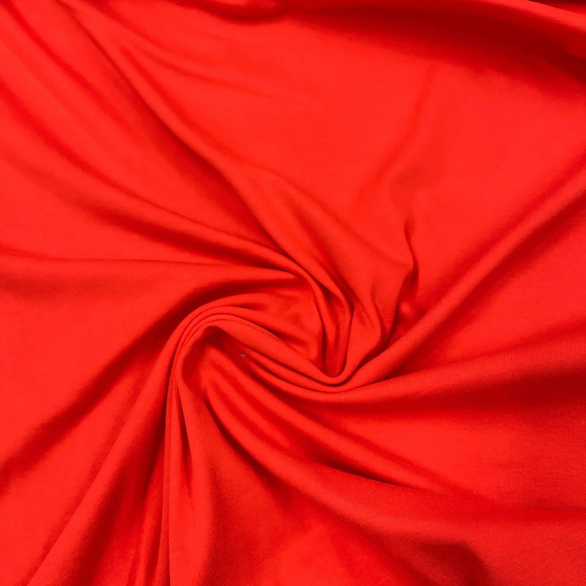 Nature's Fabrics bright red organic fabric draped in a spiral swirl