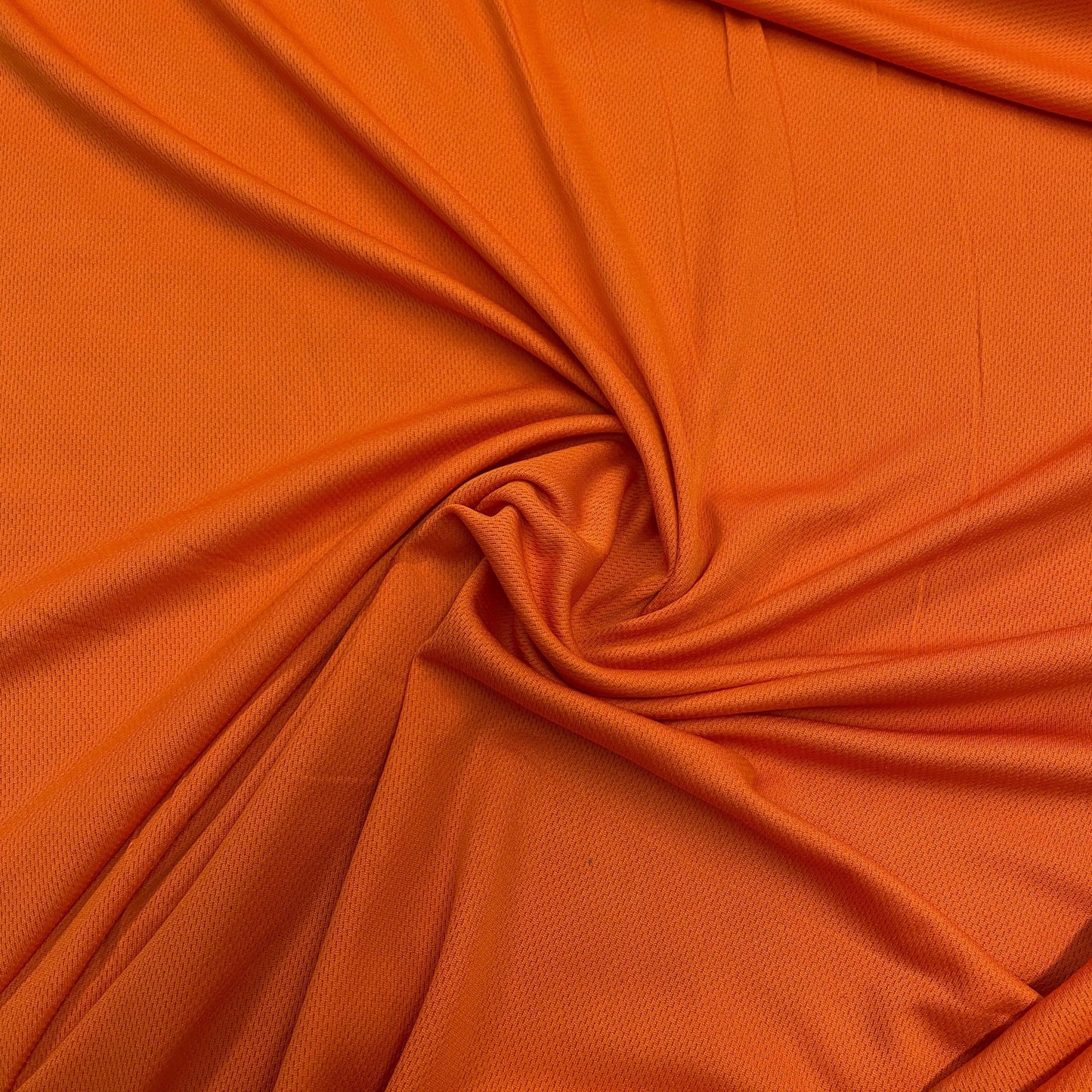 Nature's Fabrics bright orange draped fabric with a soft texture