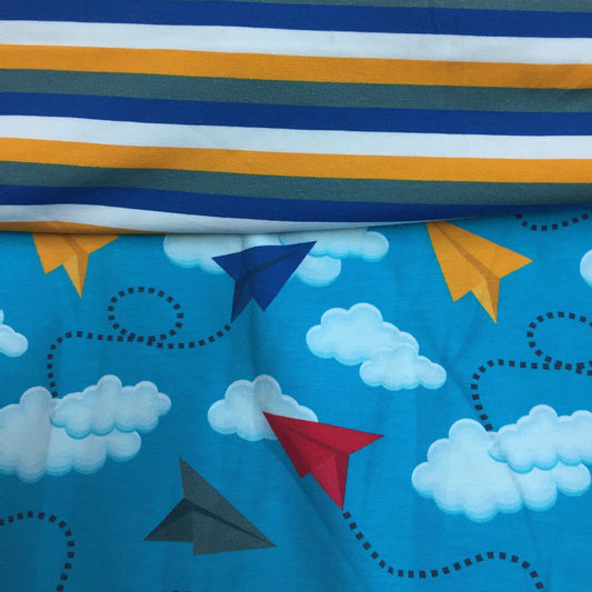 Nature's Fabrics blue fabric with paper planes and clouds next to striped fabric
