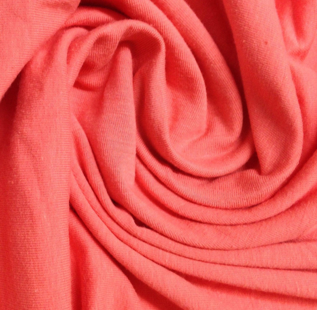 Close-up of draped coral pink organic cotton fabric from Nature's Fabrics.