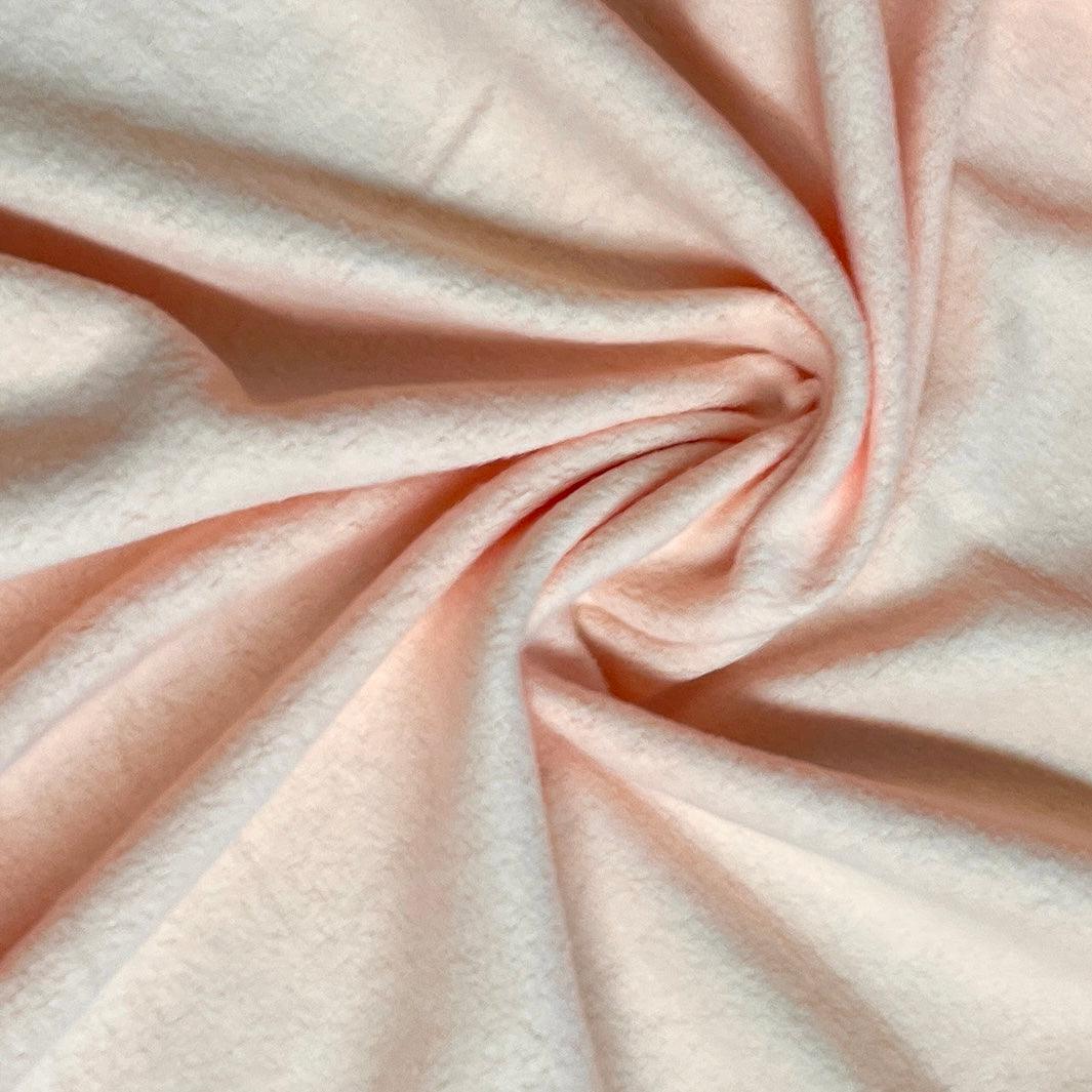 Soft peach-colored natural fabric by Nature's Fabrics, draped in elegant folds.