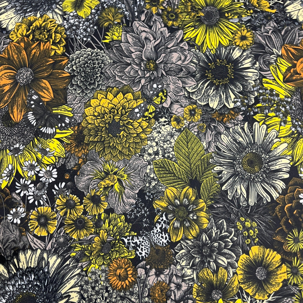 Nature's Fabrics floral print fabric with yellow and grey flowers on a black background