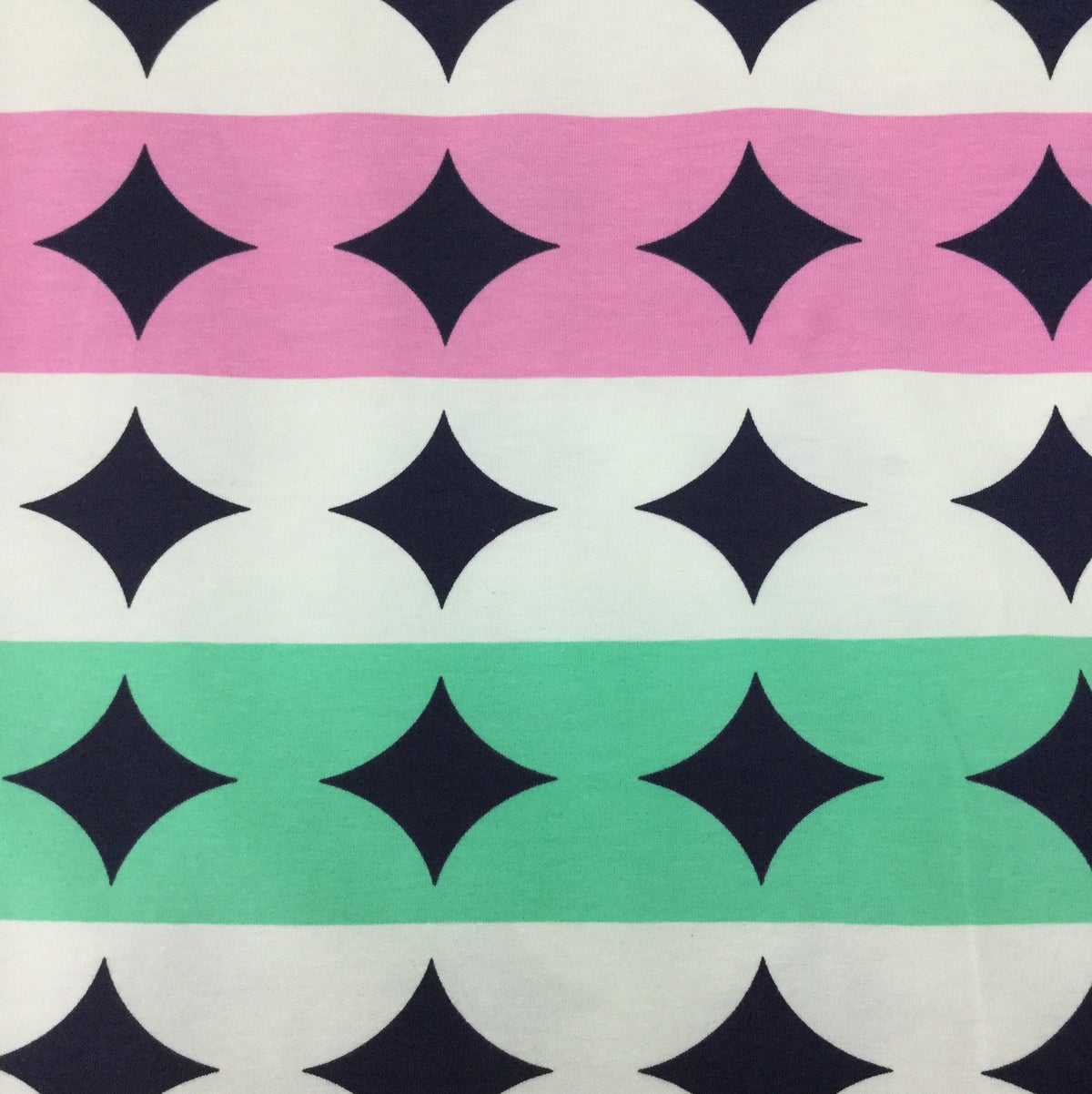 Nature's Fabrics organic cotton fabric with pink, green, and white stripes and black diamond patterns