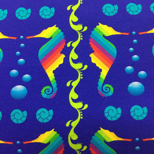Nature's Fabrics blue fabric featuring colorful rainbow seahorses and shells.