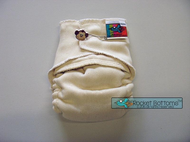 Cream-colored Rocket Bottoms reusable cloth diaper with monkey pin