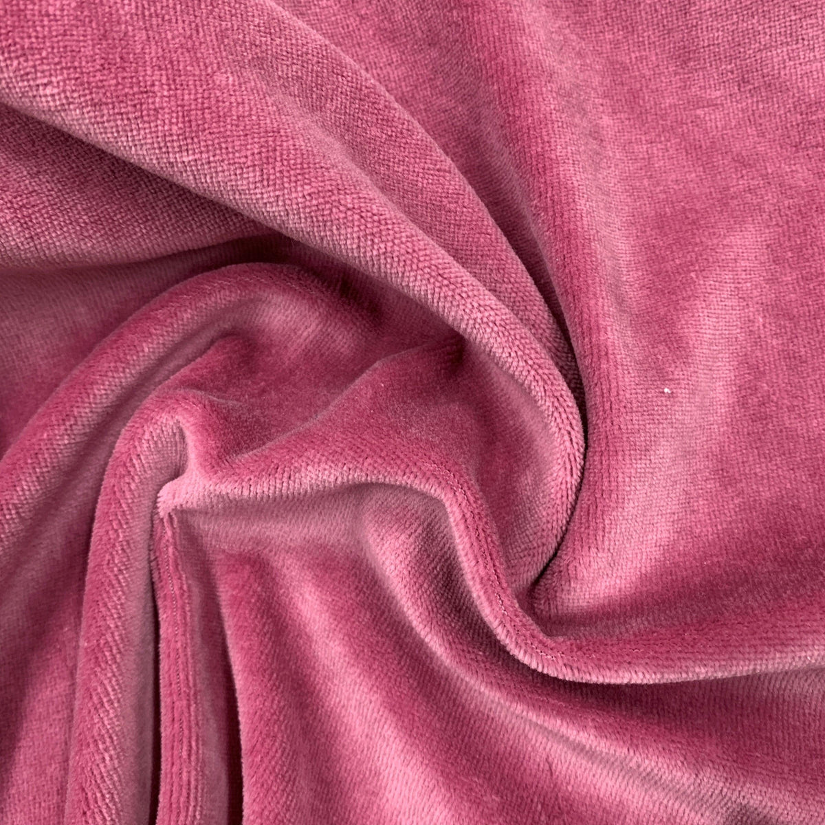 Nature's Fabrics draped pink velvet fabric with soft textures and folds.