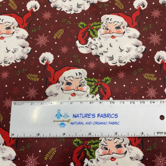 Nature's Fabrics organic cotton fabric with a vintage Santa Claus pattern and a ruler for scale.