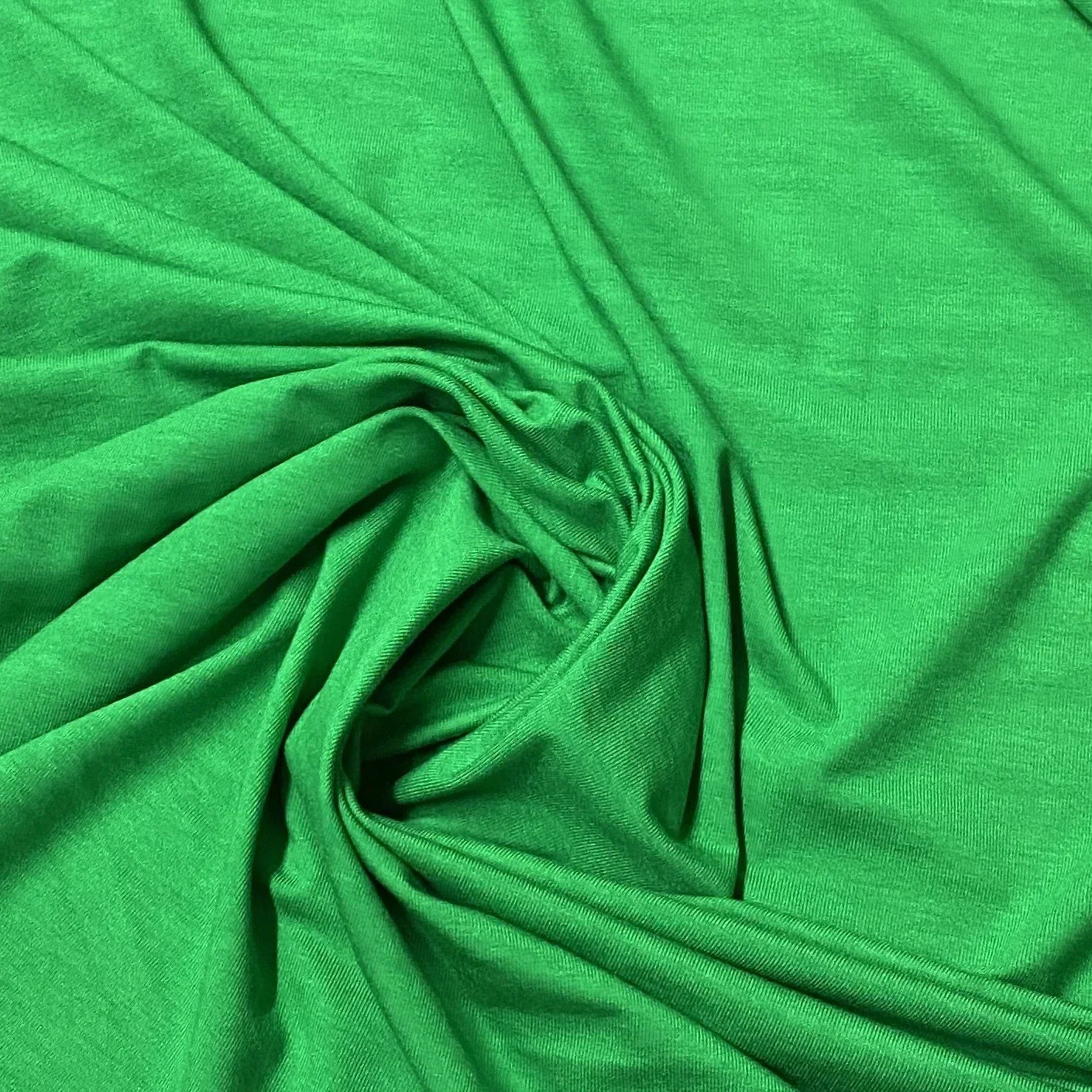 Nature's Fabrics bright green organic cotton fabric with soft folds and texture.