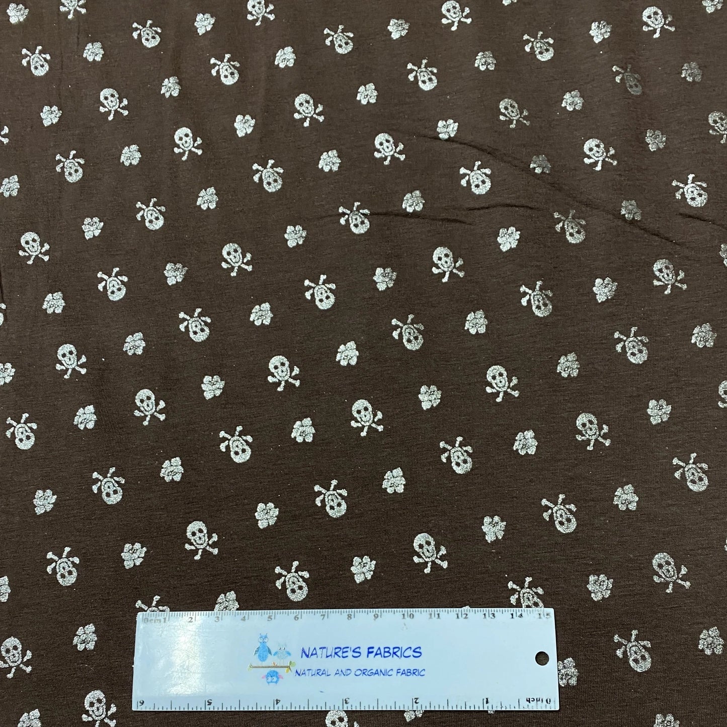 Silver Skulls on Brown Cotton/Spandex Jersey Fabric - Nature's Fabrics