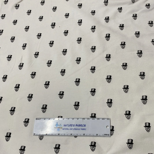 Nature's Fabrics white organic fabric with black skull and top hat print and a ruler.
