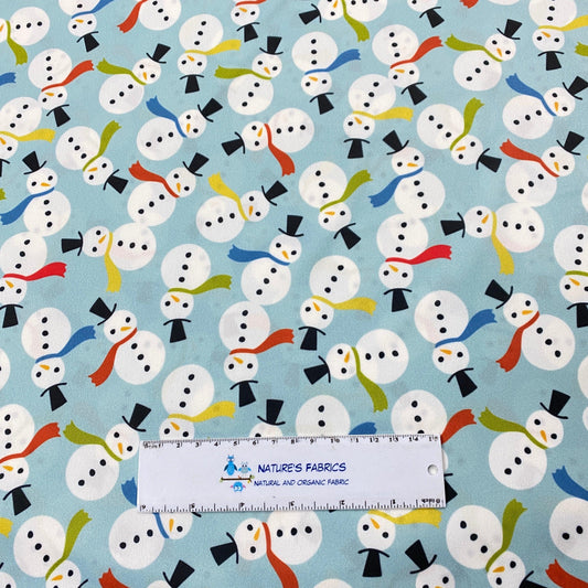 Nature's Fabrics light blue cotton fabric featuring a cute snowman pattern.