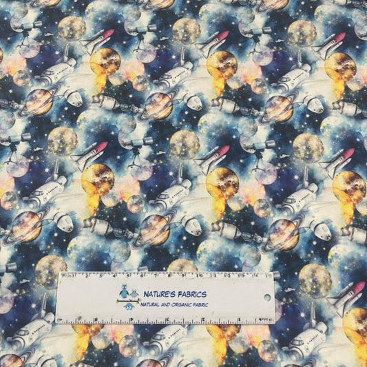 Nature's Fabrics organic cotton fabric with a space pattern featuring planets and rockets.