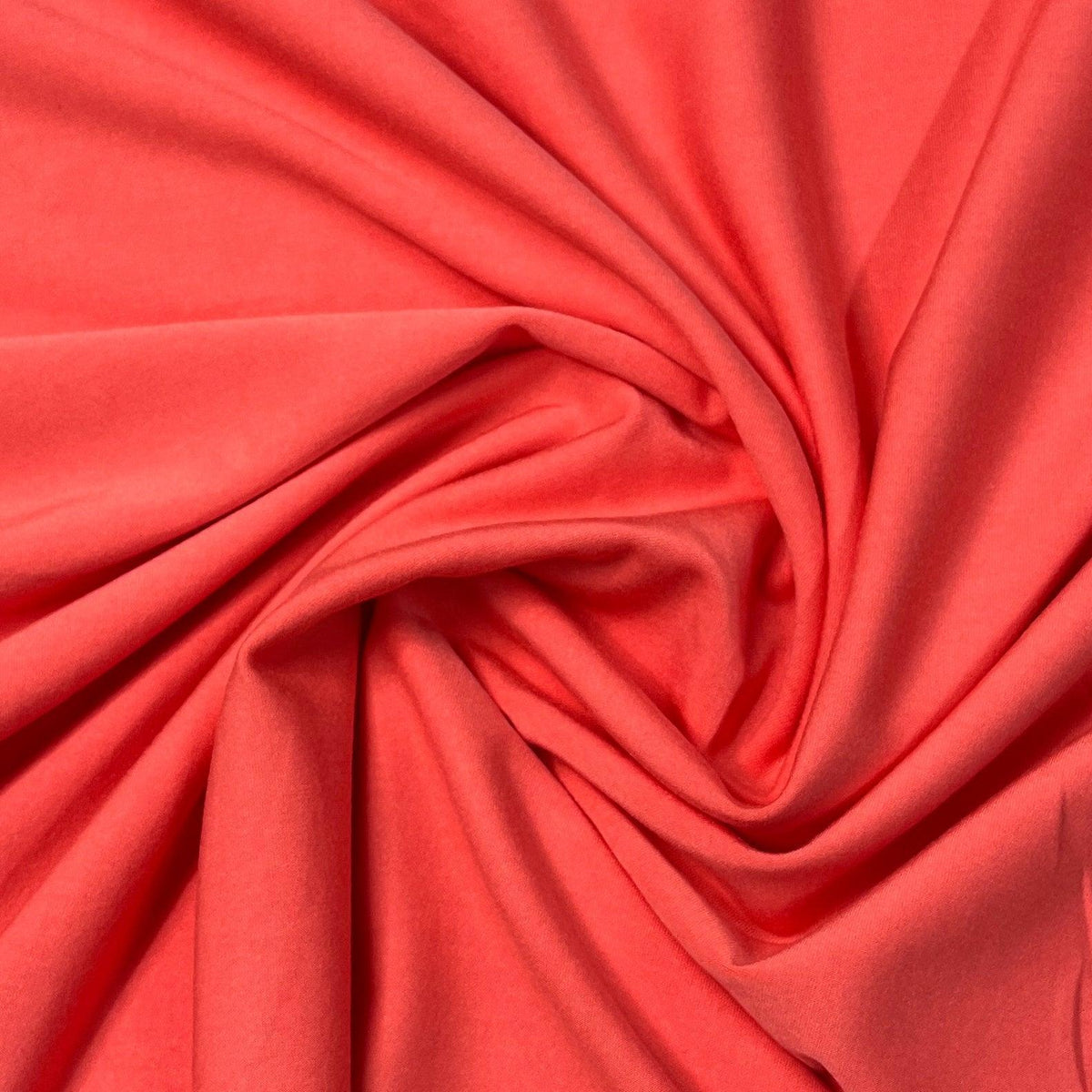Coral red natural fabric draped in a spiral by Nature's Fabrics