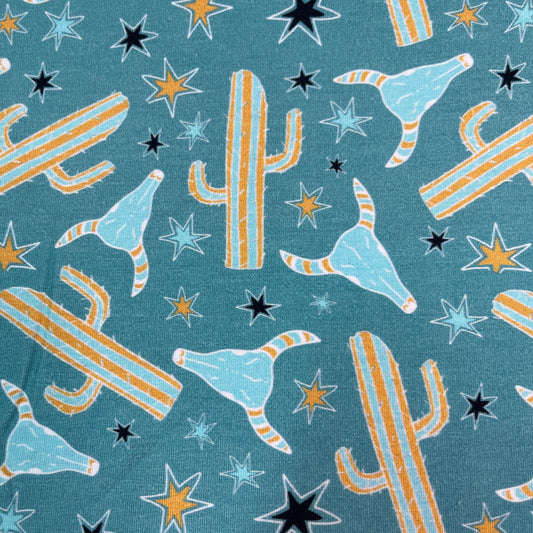 Nature's Fabrics teal fabric with yellow cacti and star patterns