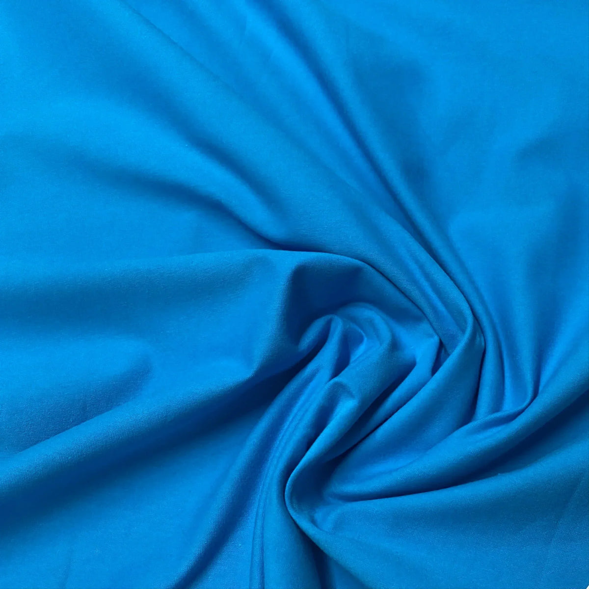 Nature's Fabrics vibrant blue premium natural fabric with soft folds and drapes.