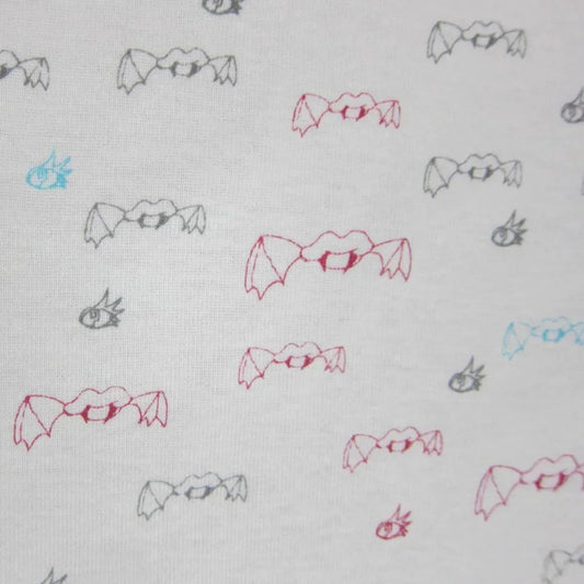 White fabric with a repeating pattern of small pink, blue, and grey bat illustrations.