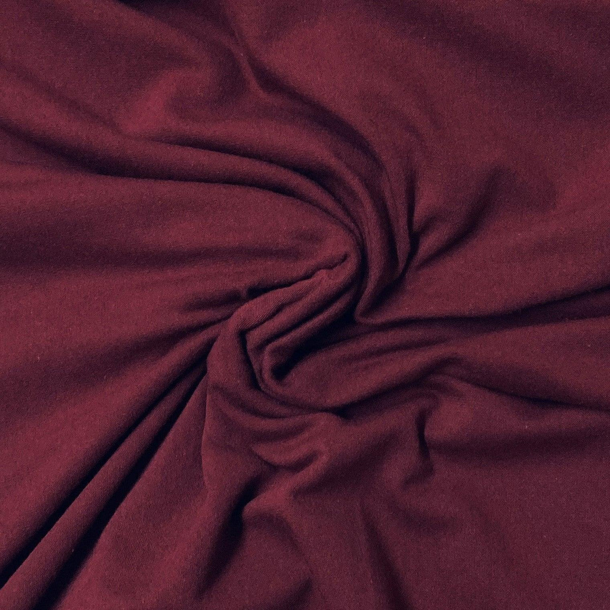 Deep burgundy premium natural fabric from Nature's Fabrics draped in soft folds.