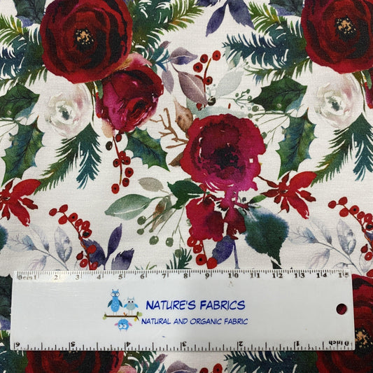 Nature's Fabrics organic cotton fabric with red roses and holly print next to a ruler.